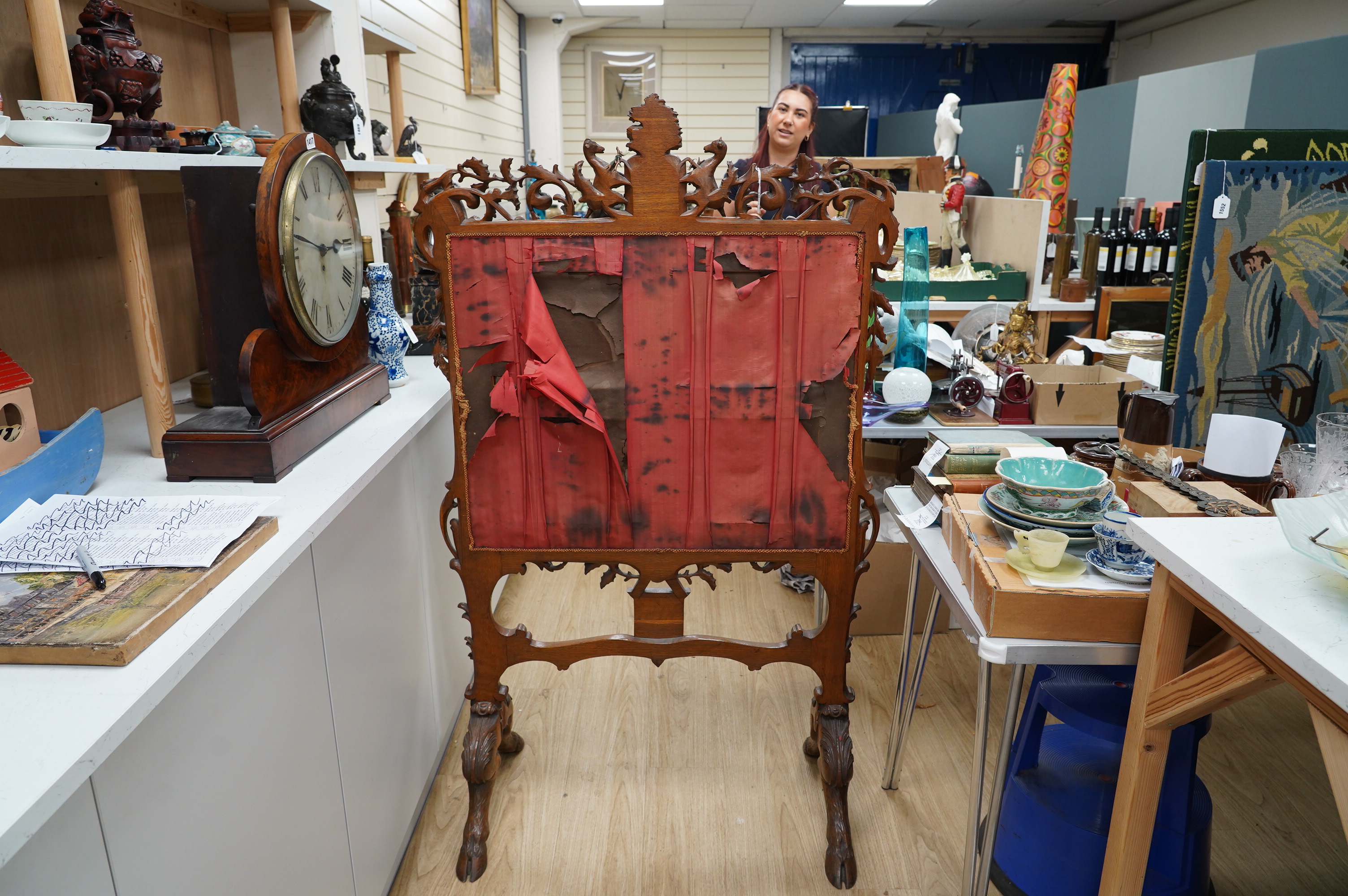 A large 19th century ornately carved oak fire screen, carved with hoof feet and a finely worked petite point panel of a Jacobean family preparing for a falconry hunt. 148cm high, 87cm wide, petite point panel 69cm wide,